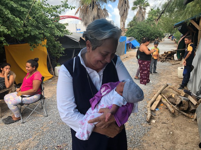 Sr. Norma Pimentel with her godchild at the migrant camp in Matamoros, Mexico, during the pandemic. The baby's birth, like most births at the camp, posed a risk to the mother and baby, as medical attention is not a given.