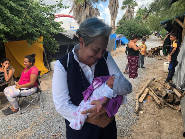 Sr. Norma Pimentel with her godchild at the migrant camp in Matamoros, Mexico, during the pandemic. The baby's birth, like most births at the camp, posed a risk to the mother and baby, as medical attention is not a given. Sr. Norma Pimentel with her godchild at the migrant camp in Matamoros, Mexico, during the pandemic. The baby's birth, like most births at the camp, posed a risk to the mother and baby, as medical attention is not a given.