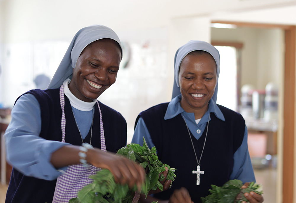 Srs. Bernadette Mumo, left, and Claudine Dushimirimana of the Little Daughters of St. Joseph prepare a lunch buffet at a kitchen in the St. Joseph Spiritual Center in a Nairobi suburb. They assist in staff oversight and operations. (Wycliff Oundo)