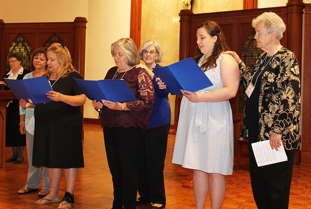The three new associates of the Ursuline Sisters of Mount St. Joseph, Kentucky, read their commitments at the order's June 2019 Associates and Sisters Day with their contact companions. From left: Ursuline Sr. Amelia Stenger, congregational leader; associ
