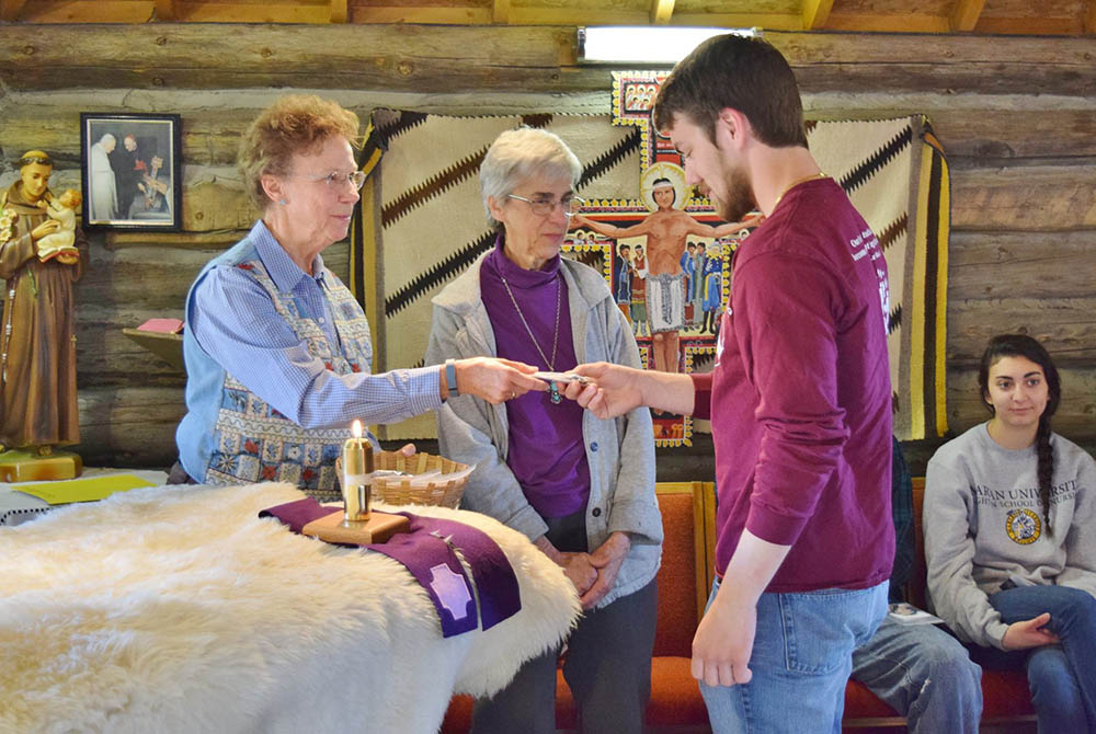 Sr. Patricia Bietsch presents a Tohatchi Cross to a student from Marian University in Indianapolis, during their immersion trip to St. Mary Mission, March 2016. (Provided photo) Sr. Patricia Bietsch presents a Tohatchi Cross to a student from Marian University in Indianapolis, during their immersion trip to St. Mary Mission, March 2016. (Provided photo)