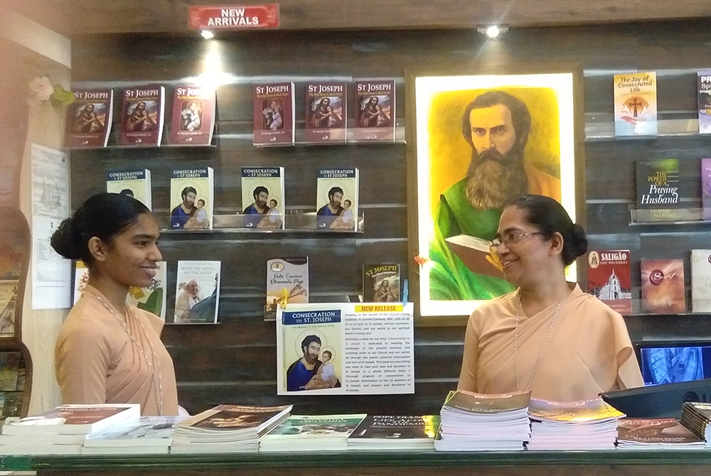 Sr. Priyadarshini Nayak, left, and Sr. Priya Paul are pictured at the Pauline Book Centre in Panaji, Goa, in India. A picture of St. Paul hangs behind them. (Courtesy of Lissy Maruthanakuzhy)