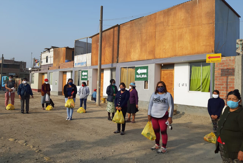 Women distribute food in Cajamarquilla outside Lima, Peru, buying large quantities at affordable prices to sell cheaply to the community while making a small profit for themselves, said Sr. Socorro Palomino. (Courtesy of Socorro Palomino)