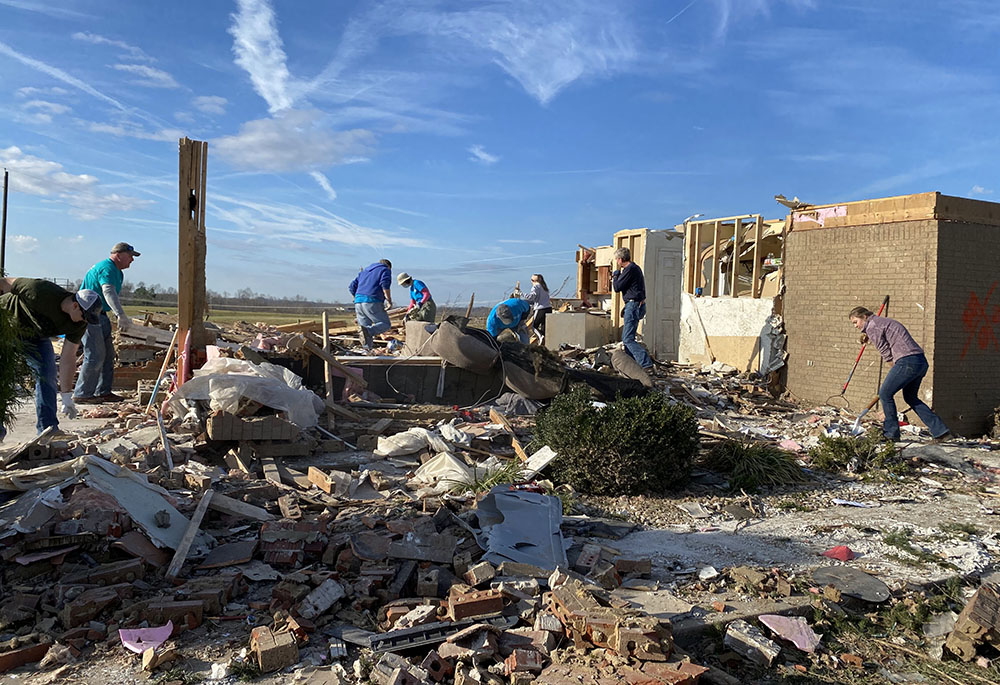 Volunteers with the Sisters of Charity of Nazareth sort through and clear debris from a home severely damaged by tornadoes in Campbellsville, Kentucky, accompanied by the surviving family and friends. (Courtesy of Ellen Sprigg)