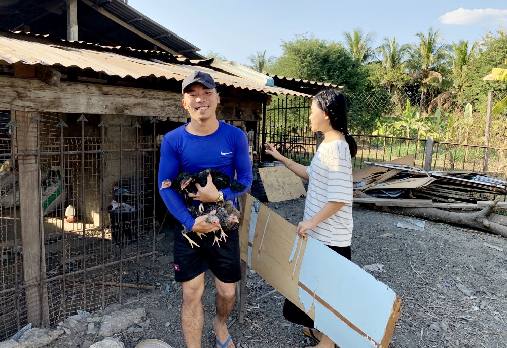 Students help with chores around the Nazareth Center, such as feeding chickens and ducks. (Akarath Soukhaphon)