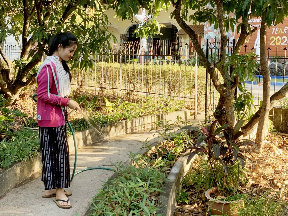 A student waters the garden at the Nazareth Center. (Akarath Soukhaphon)