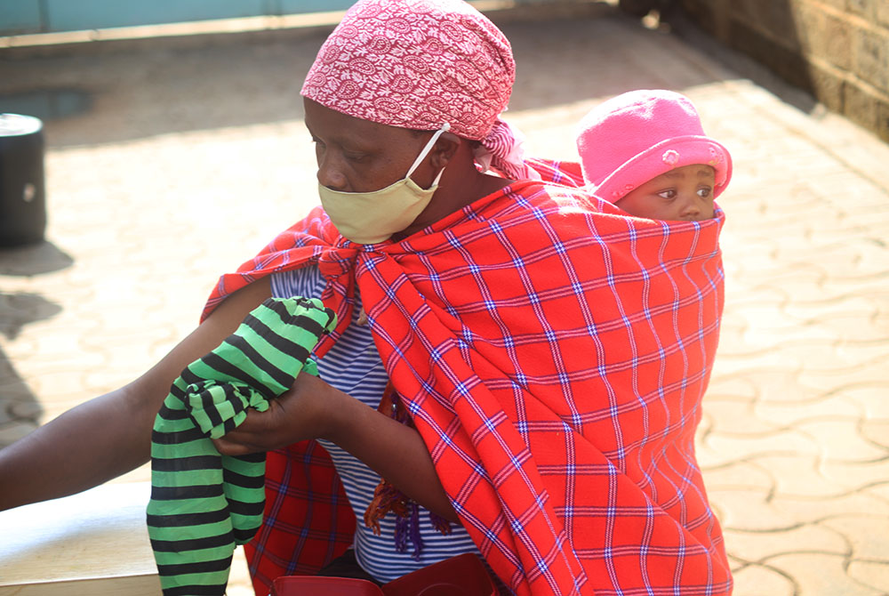 Joyce Nyokabi, 34, carries her child on her back in Dagoreti slum on the outskirts of Nairobi. Nyokabi started a small grocery business after securing a loan from Savings and Internal Lending Communities, a project run by the Salesian Sisters to empower p