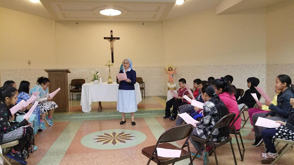 Sr. Alice Thepouthay, a member of the Sisters of Charity of St. Joan Antida and a pastoral associate for the Lao at St. Michael Parish in Milwaukee, with Hmong and Lao children (Courtesy of Alice Thepouthay)