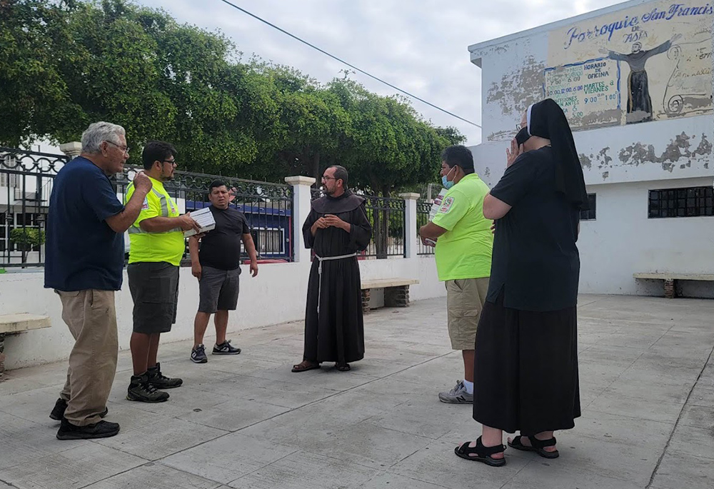 Aguilas del Desierto team members, from left, Vicente Rodriguez, Maurizio Vitela, Ruben Figueroa, Ely Ortiz and Sr. Marie Louise Edwards visit Franciscan Br. Augustine Garcia (center) at his migrant shelter at Mazatlan. (Courtesy of Aguilas del Desierto)