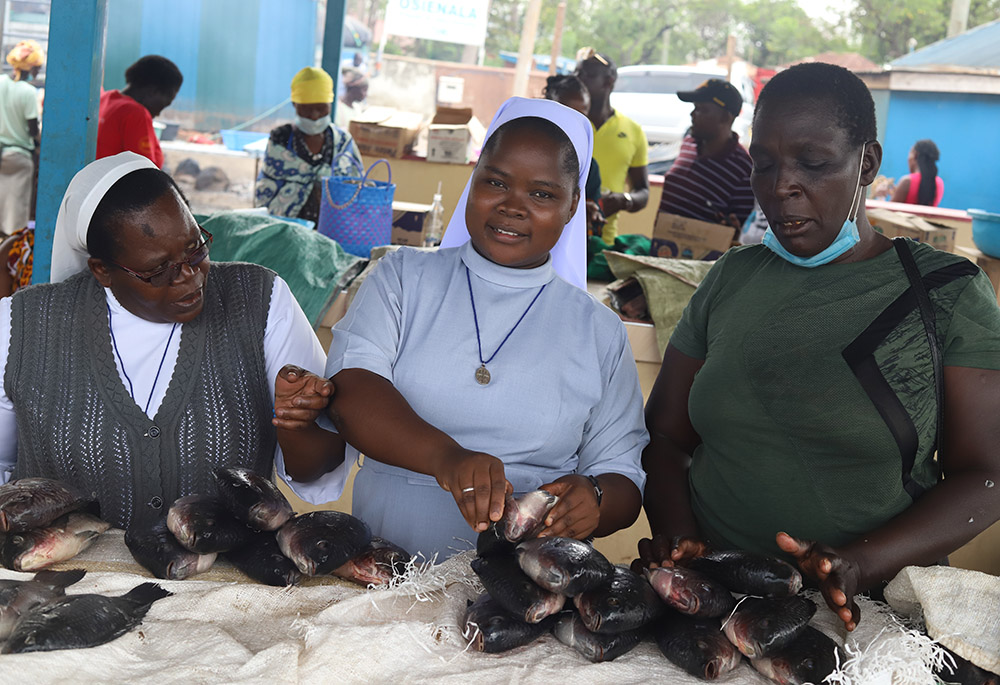 Srs. Christine Auma (from left) and Josephine Musungu, who are members of the Sisters of Mary of Kakamega, interact with women fishmongers at Dunga Beach market in Kisumu in southwestern Kenya on Nov. 6, 2021. (GSR photo/Doreen Ajiambo)