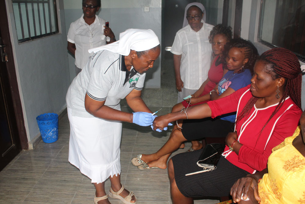 Sr. Sylvia Ndubuaku draws a blood sample from a patient for a free test at the Family Life Centre in Mbribit Itam in Akwa Ibom state, Nigeria, in 2020. (Kelechukwu Iruoma)