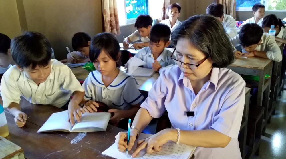 A volunteer Vietnamese teacher gives children a writing exercise. (Sr. Mary Nguyen Thi Phuong Lan)
