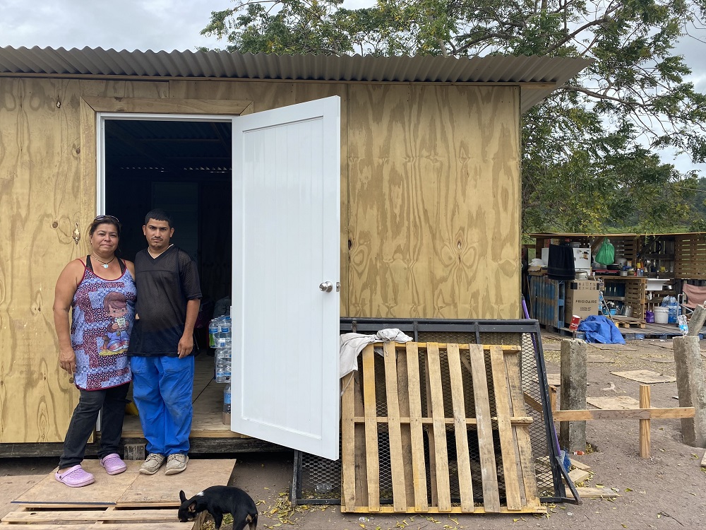 Wanda Rodríguez and her son, Steven, stand outside the small room where the family has been sleeping since their home in Guánica, Puerto Rico, was designated unlivable after the Jan. 7 earthquake. Behind them is their makeshift kitchen. (GSR file photo)