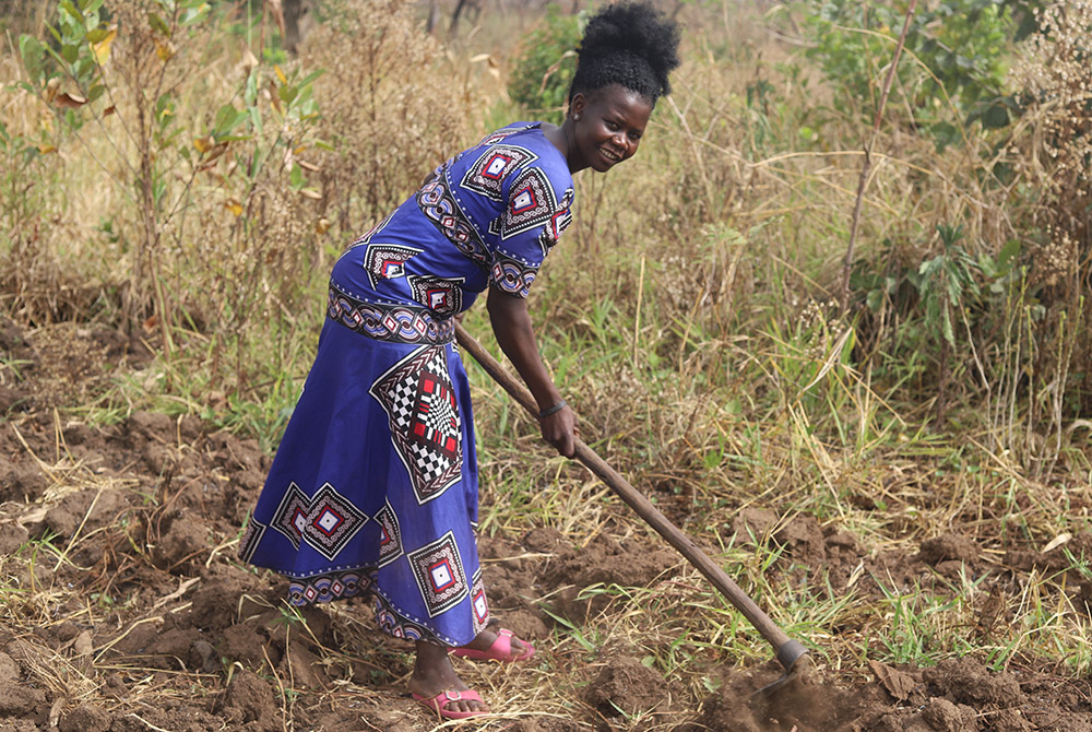 Rose Geno, 30, tills her land in preparation for the next planting season, which began in March. With the skills and support she received from Sr. Lucy Akera and Salesian missionaries, she hopes to increase her harvest. Geno started farming to mitigate fo Rose Geno, 30, tills her land in preparation for the next planting season, which began in March. With the skills and support she received from Sr. Lucy Akera and Salesian missionaries, she hopes to increase her harvest. Geno started farming to mitigate fo