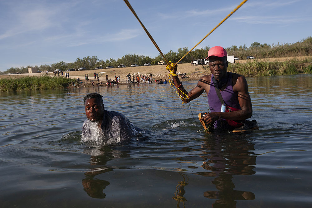 A rope line across the Rio Grande guides Haitian immigrants on their return to the camp in Ciudad Acuña, Mexico, from Del Rio, Texas, Sept. 22. The men wouldn't say why they were returning. (Nuri Vallbona)