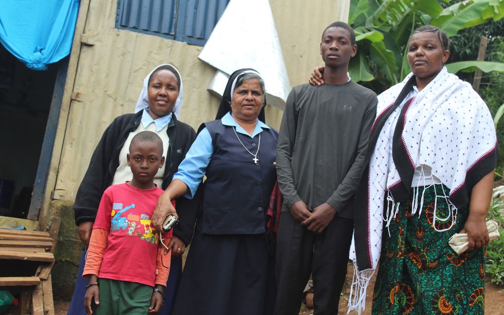 Paulina Masawe, right, who was pressured by her husband to relinquish her children to traffickers, and Stanley Joakim, second from right, stand with Catholic sisters and Stanley's younger brother in Arusha, Tanzania
