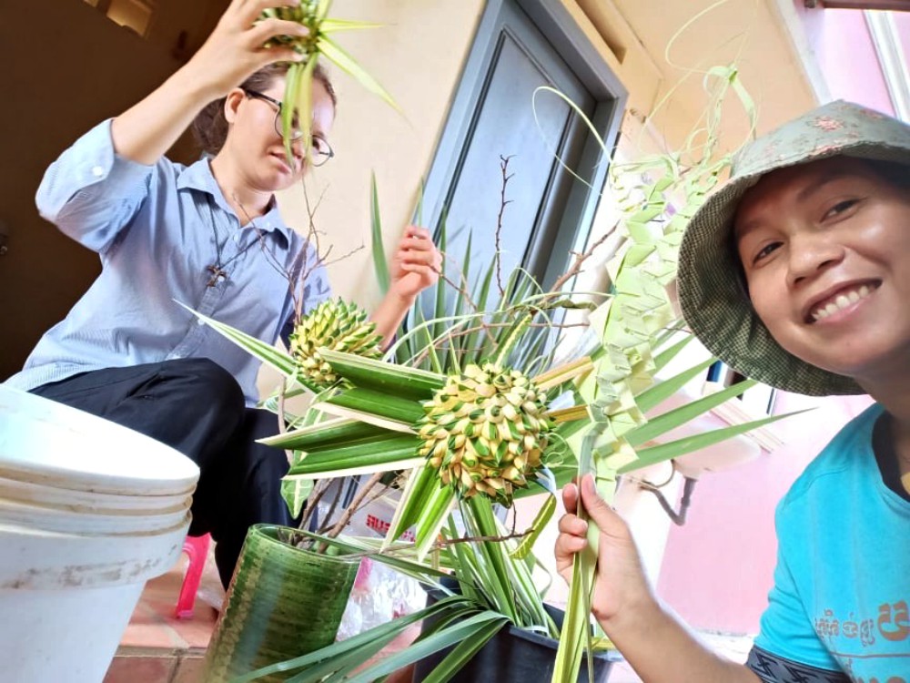 Srs. Hill Pen, left, and Sokny Nheb, right, of the Lovers of the Holy Cross prepare for Palm Sunday. (Akarath Soukhaphon)