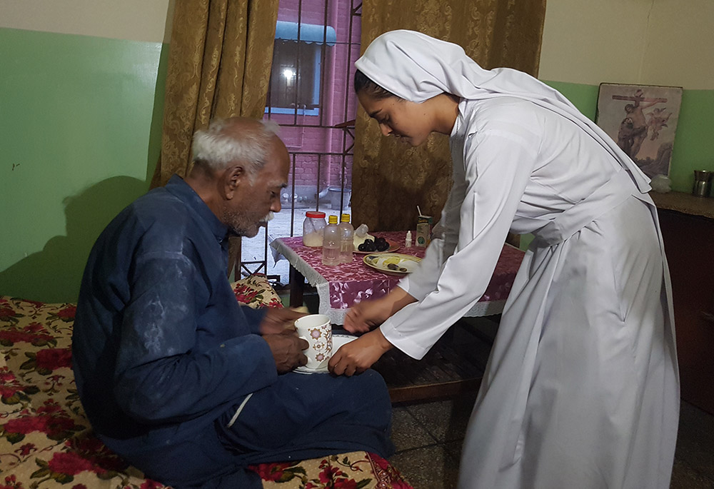 A Sister of Charity of Jesus and Mary serves tea to a resident of Shakina Home for the Aged in Youhanabad, Lahore, Pakistan. (Kamran Chaudhry)