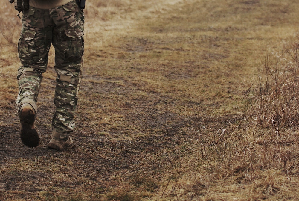 A person in camouflage holding a gun in the woods photo – Free Military  Image on Unsplash