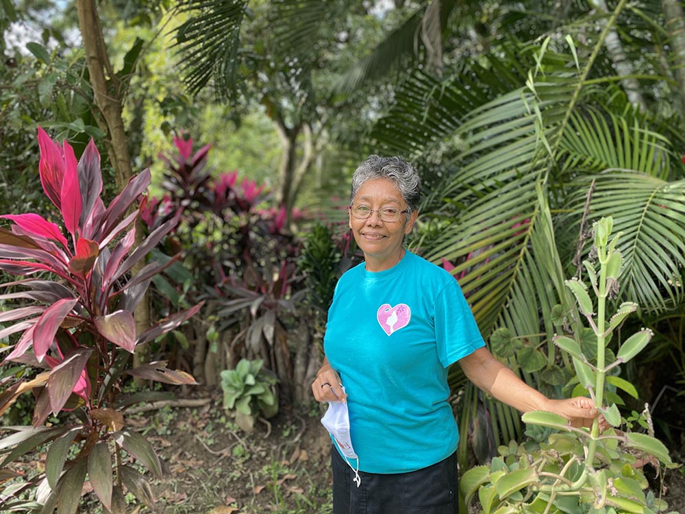 La hermana Trochez con camisa azul y al fondo un jardín. 