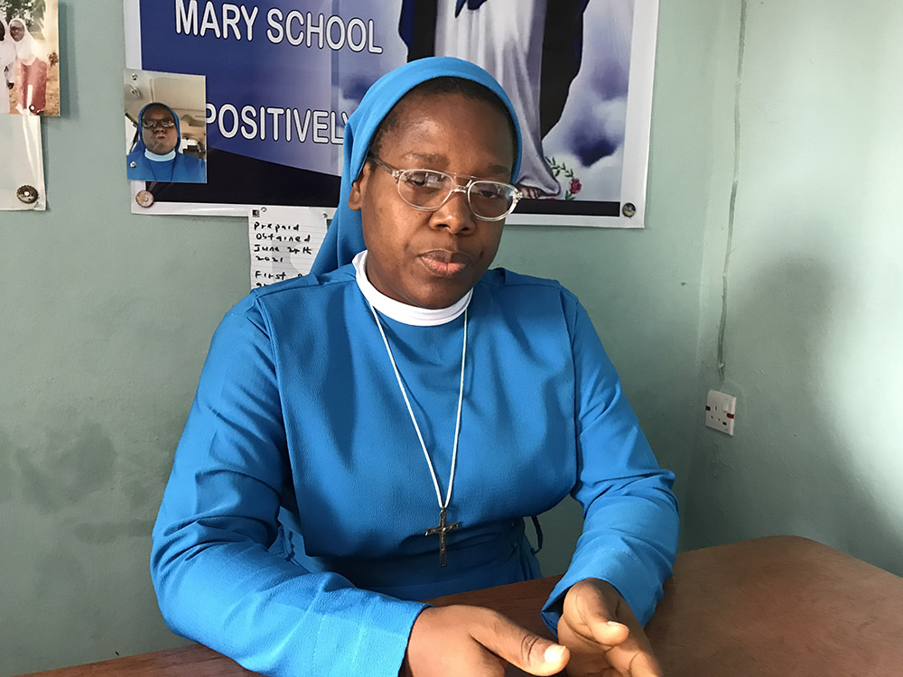 Sentada y vestida con su hábito azul, la Hna. Dorothy Chinyere Okoli, de las Hermanas Misioneras de San Juan Pablo II de María en Nkwelle Ezunaka, Anambra, Nigeria. 