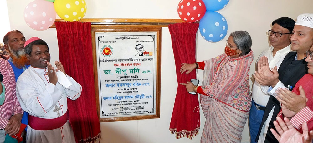 Bishop Sebastian Tudu, at left, claps as Dipu Moni, Bangladesh's education minister, shows a plaque inaugurating St. Francis Xavier High School's new building March 14 in Dinajpur, northern Bangladesh. At right next to Moni is Iqubalur Rahim.