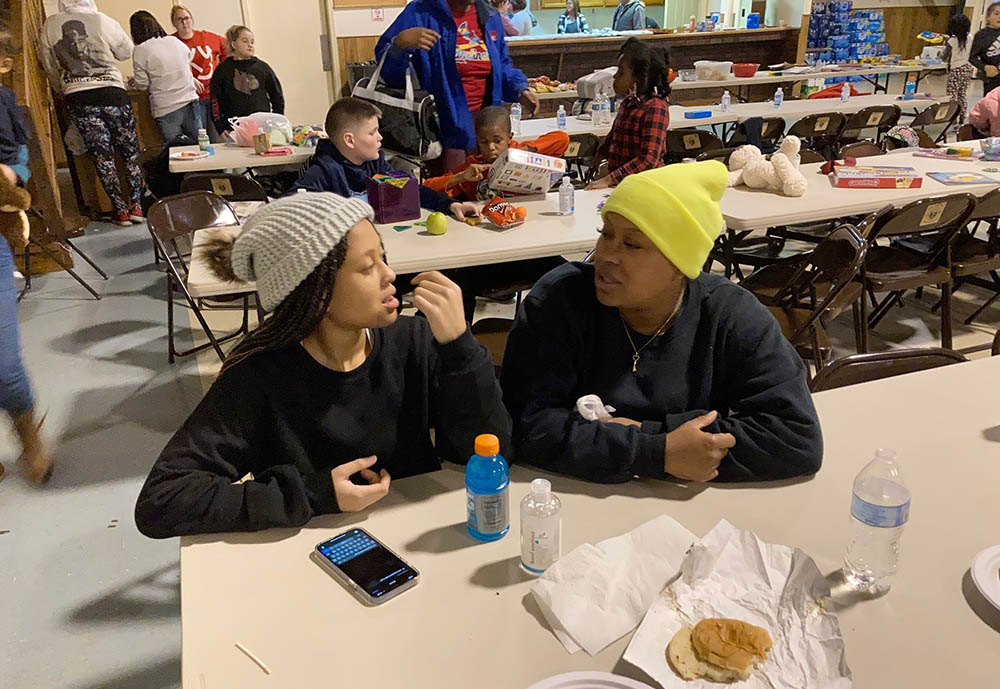 Courtney Saxton chats with her 13-year-old daughter, Querria, at the St. Jerome Parish hall in Fancy Farm, Kentucky, on Dec. 11. The family's Mayfield, Kentucky, home was destroyed by a tornado. (AP/Bruce Schreiner)