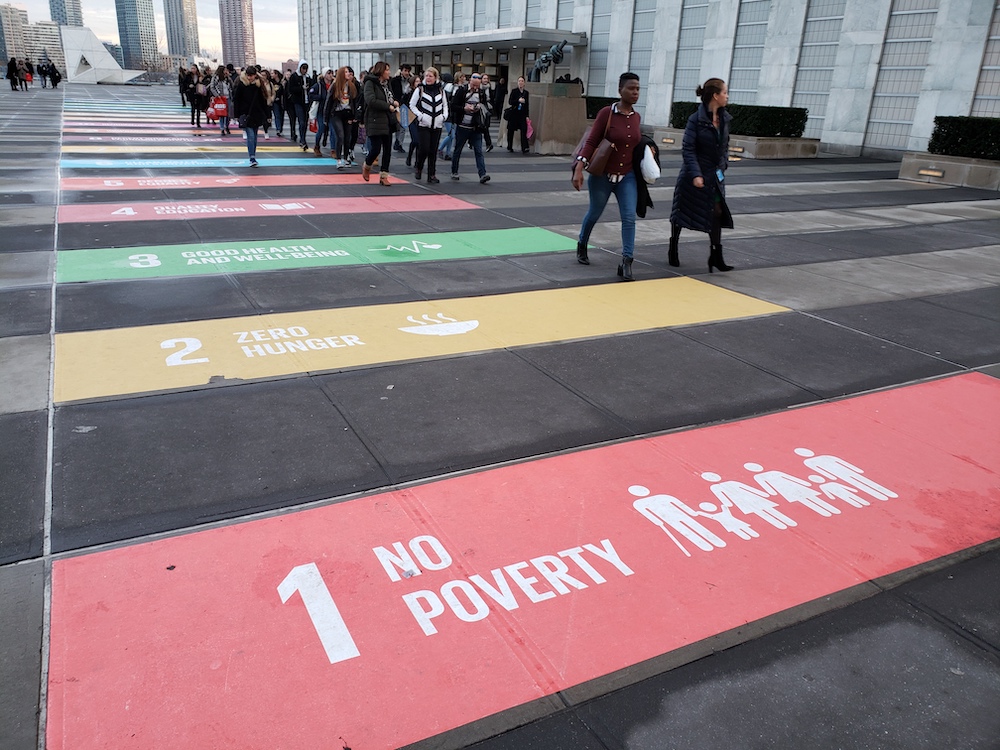 Phot of fhe entrance to the United Nations headquarters in New York displaying the world body's 17 sustainable development goals painted on the pavement (GSR photo/Chris Herlinger)