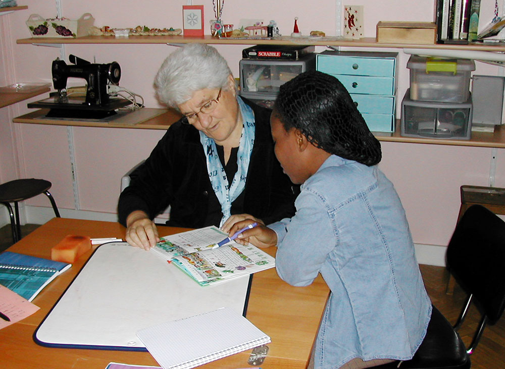 Good Shepherd Sr. Marie-Hélène Halligon, left, teaches the French language to a survivor of trafficking. (Courtesy of Marie-Hélène Halligon)