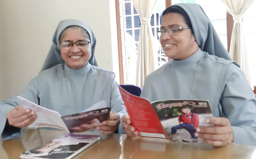 Sr. Tessy Kodiyil, left, and Sr. Roselin Kachapilly review Aswas magazine at Aswas center in Changampuzha Nagar, Kerala, India. (Courtesy of Tessy Kodiyil)