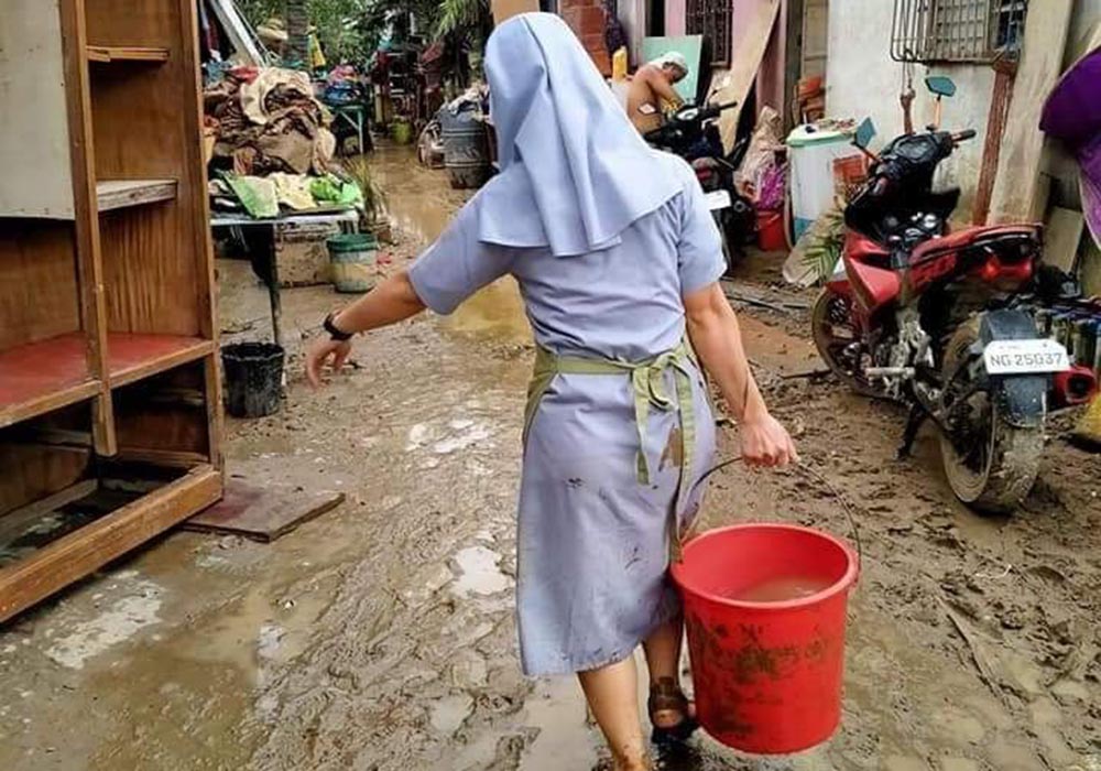 Sister of the Daughters of St. Anne helped residents clean up mud in Bagong Silangan, an area of Quezon City in metropolitan Manila after flooding caused by Typhoon Ulysses, the local name for Typhoon Vamco, which hit the region Nov. 11. (Courtesy of Daug