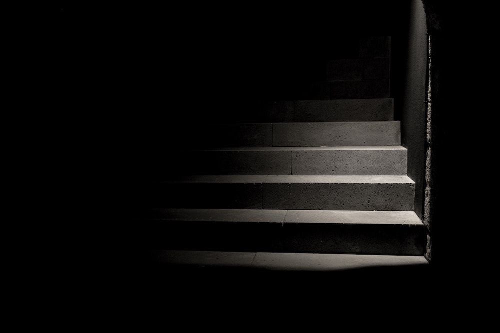A dark staircase (Unsplash/Carolina Pimenta)