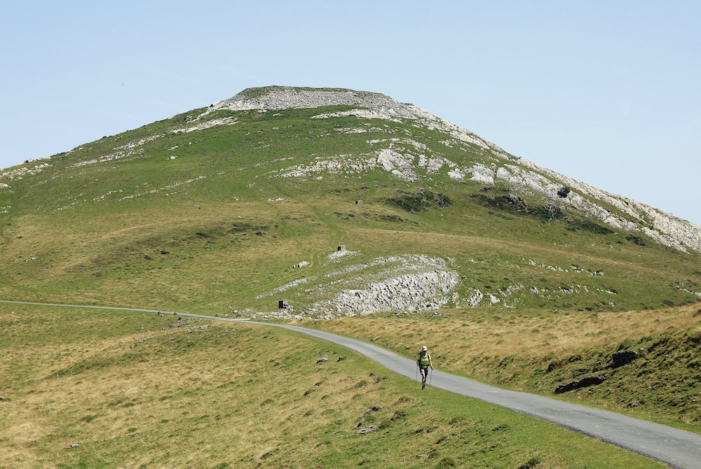 Person walking a path down a large hill