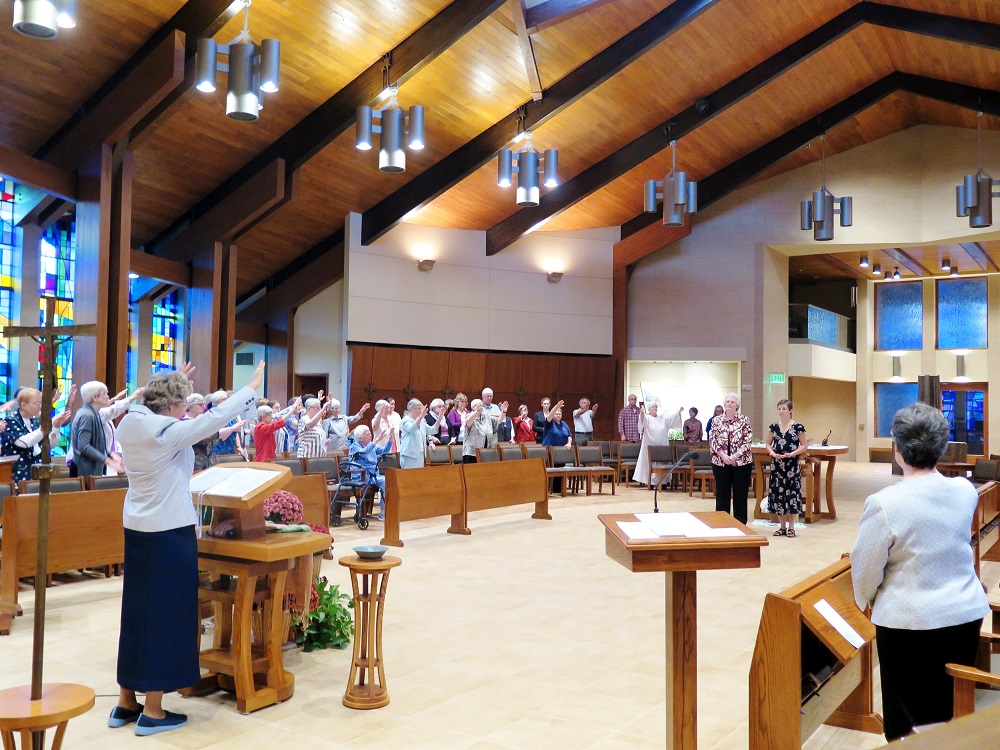 The Benedictine Sisters of Erie, Pennsylvania, bless Sr. Valerie Luckey, in black dress, at her first profession Oct. 21, 2017. (Courtesy of the Benedictine Sisters of Erie)