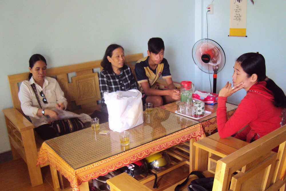 Sr. Lucia Duong Thi Tam (left) and volunteers offer a gift to Mary Luong Thi Xuan Phuong (in red). After meeting the sisters in her recovery from scrofula, Phuong now teaches at a daycare center run by the Sisters of St. Paul of Chartres and volunteers with the Da Nang diocese's HIV prevention program (Photo: Joachim Pham).