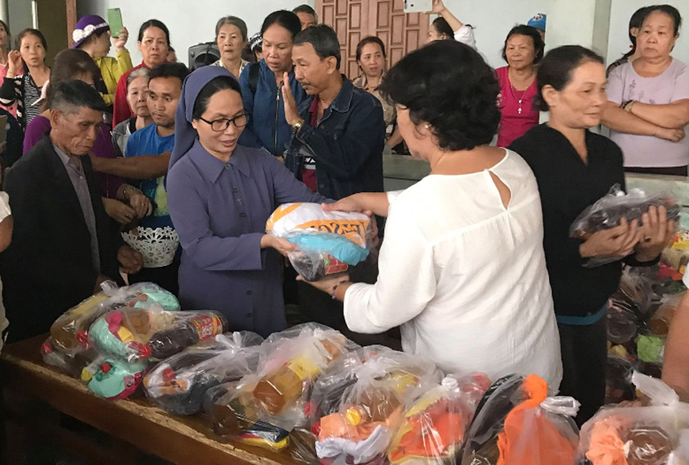 Sr. Maria Goretti Le Thi Van Anh of the Lovers of the Holy Cross gives gifts to people in need to celebrate the Tet festival Feb. 4 in Vietnam. (Joachim Pham)