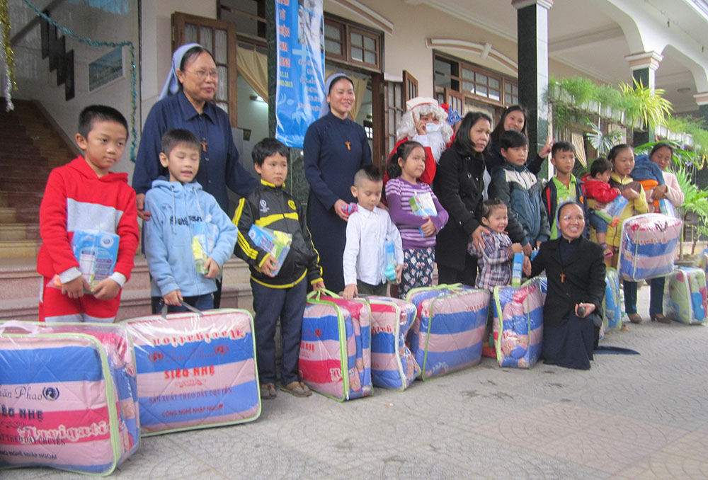 Daughters of Mary of the Immaculate Conception sisters in Hue on Dec. 3 offer blankets to children affected by COVID-19 and natural disasters. (Joachim Pham)