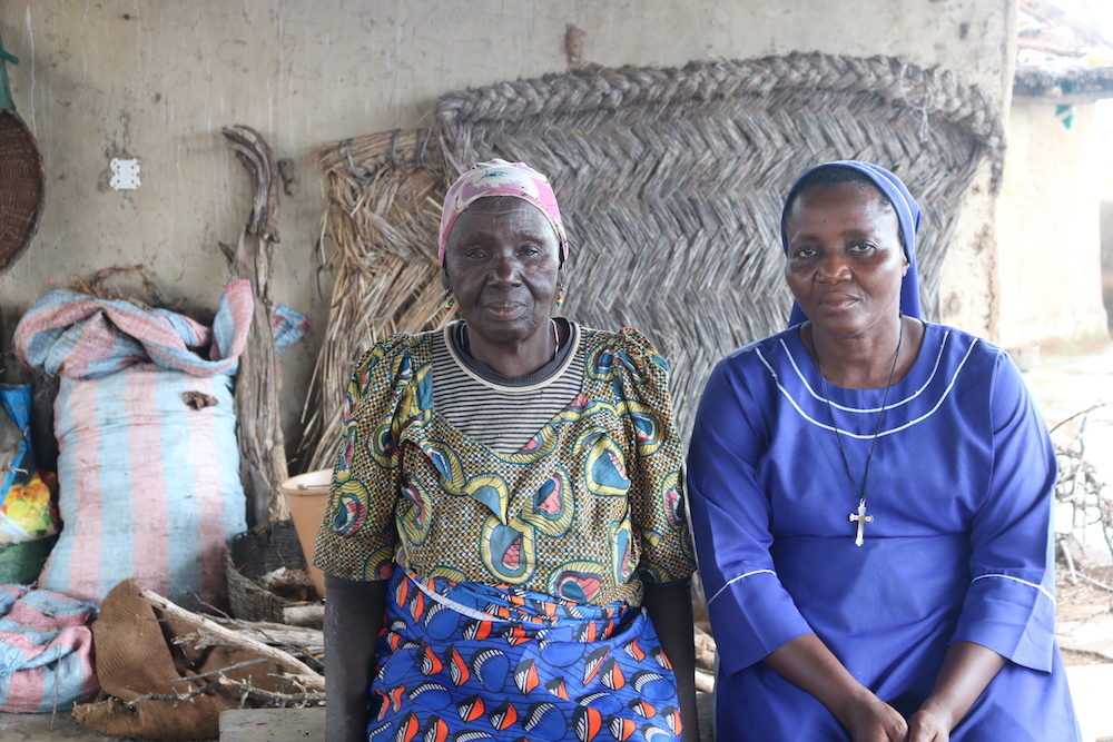 Nato Blenjuo, a la izquierda, sentada con la hermana Ruphina Anosike en el campamento de Gushegu, en el norte de Ghana. Blenjuo, que lleva más de dos décadas en el campamento de Gushegu, fue expulsada de su casa porque los aldeanos sospechaban que practicaba la brujería. (Foto: Doreen Ajiambo)