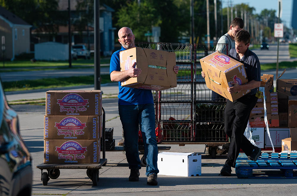 Deacon Bob Hornacek, center, helps unload boxes of lettuce and other produce from a pallet and onto a cart for Paul's Pantry in Green Bay, Wisconsin, Sept. 16. (CNS/The Compass/Sam Lucero)