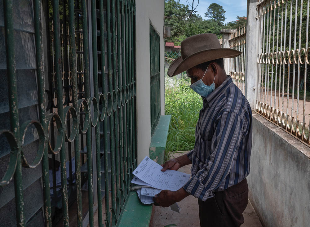 A resident of Yorito prepares his voter registration forms ahead of elections in November.