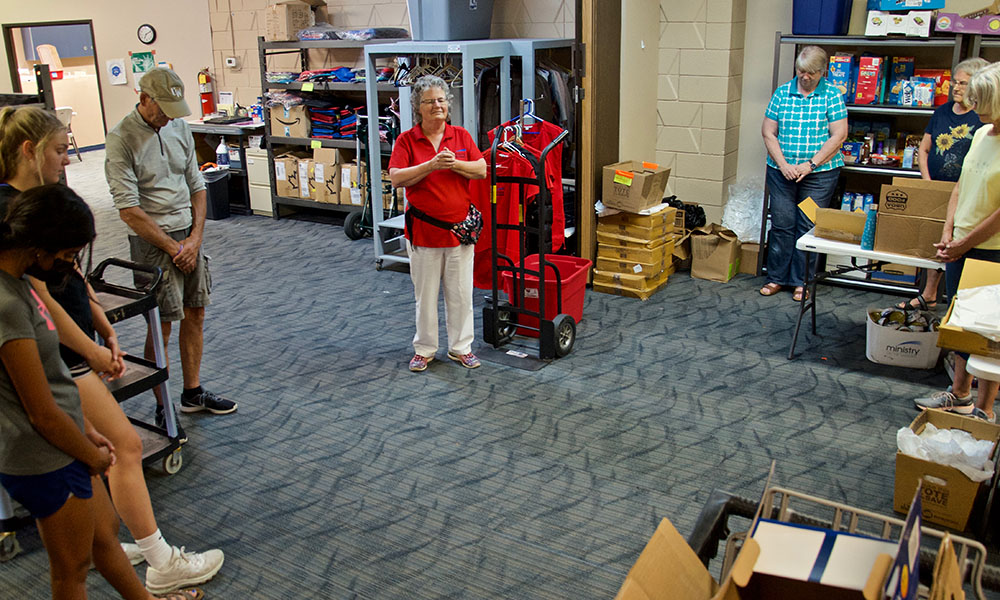 Volunteers gather in prayer at the end of a twice-weekly food pantry held at Ministry on the Margins in Bismarck, North Dakota. Leading the prayer is Benedictine Sr. Kathleen Atkinson (in red), the agency's director. (GSR photo/Dan Stockman)