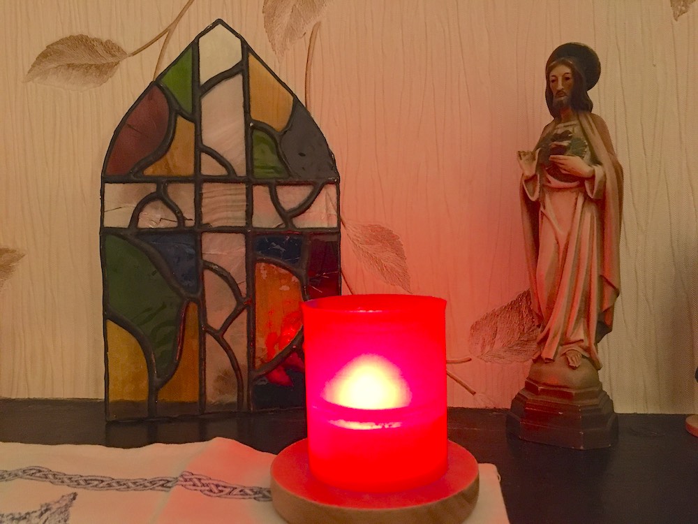 Candle and statue of Jesus on a table (Kathryn Press)