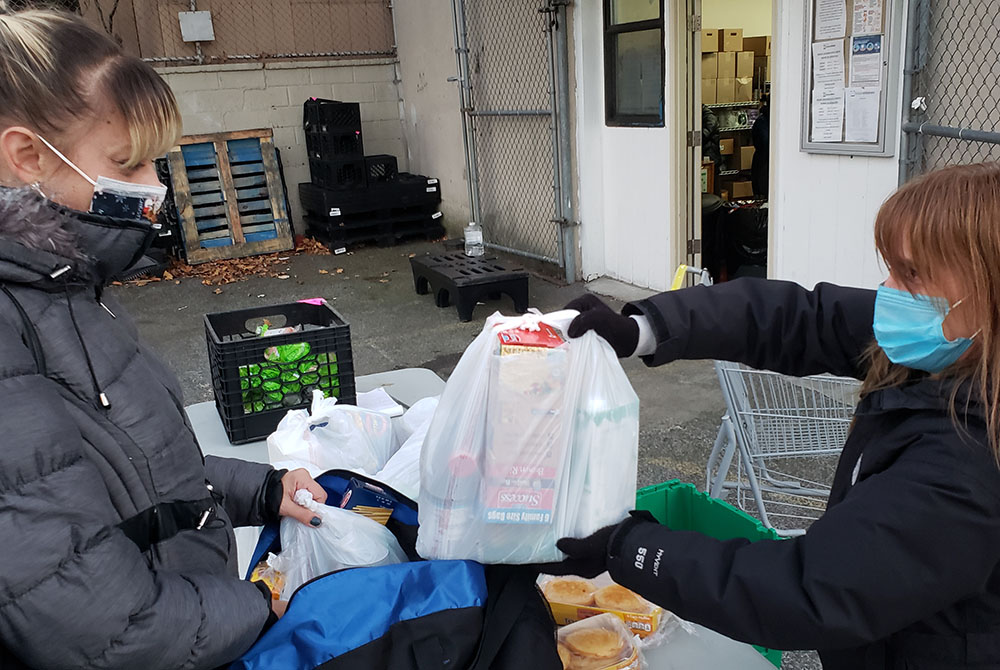 Hour Children food pantry participant and Queens resident Jackie Terrasi, left, receives a food package from pantry coordinator Kellie Phelan. The pantry, based in New York City, is an initiative of Hour Children, a ministry headed by St. Joseph Sr. Tesa 