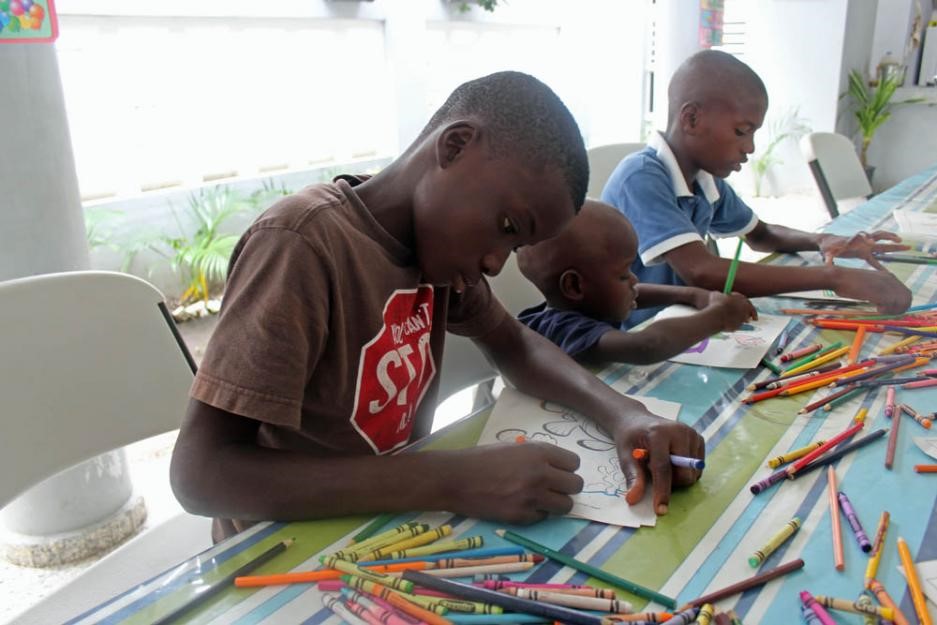 Children draw with crayons in a church-run shelter. Children draw with crayons in a church-run shelter.