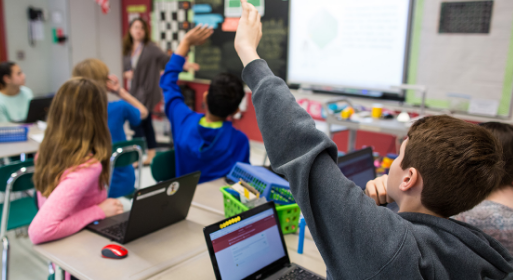 Youth in a classroom raising their hands to answer questions