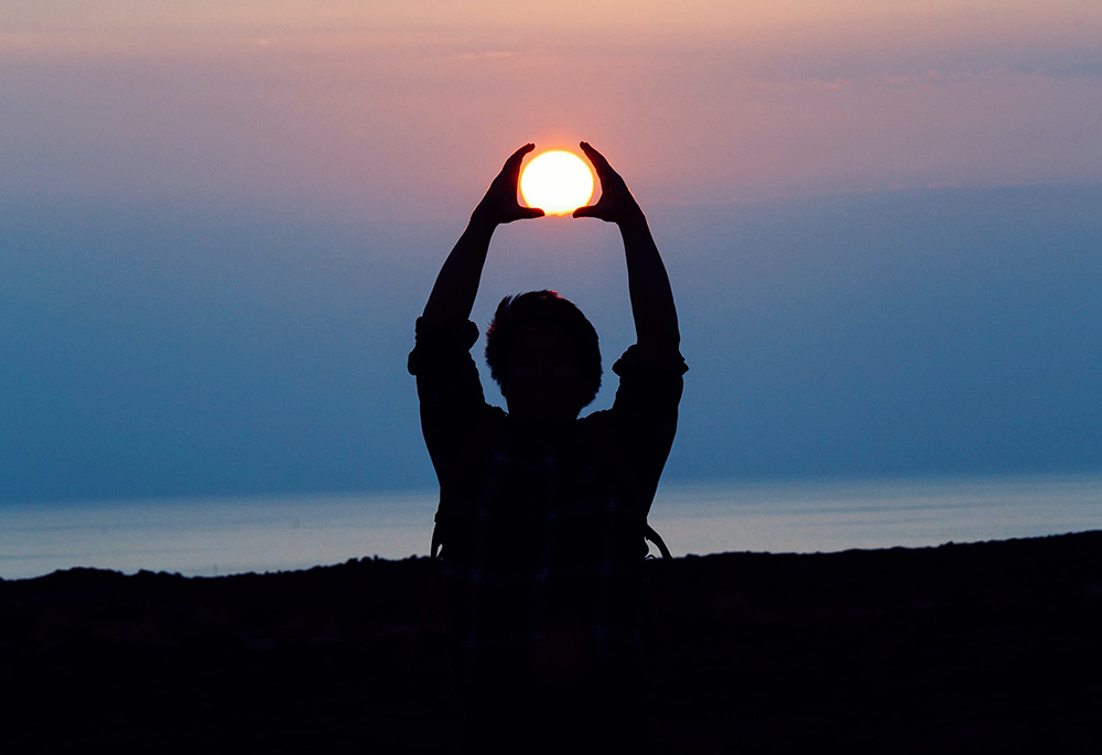 Hands aligned with the sun (Unsplash/Jason Leung)