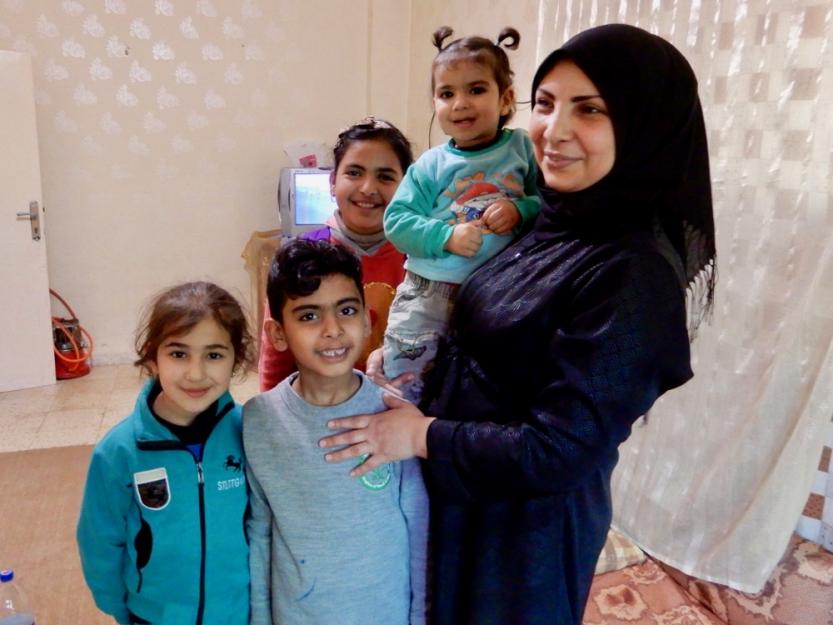 Hanaa Abdullah poses with her children and her brother's children in her brother's apartment in Madaba, Jordan.
