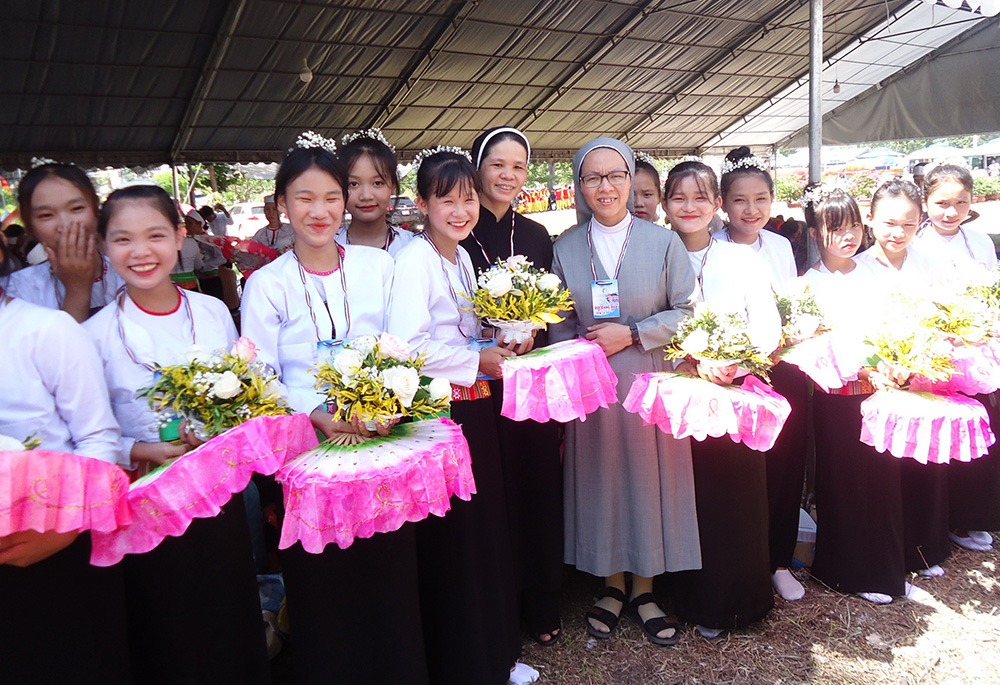 Sr. Pham Thi Hien (in black) is pictured with Muong ethnic dancers at the 222-year-old site. (Joachim Pham)
