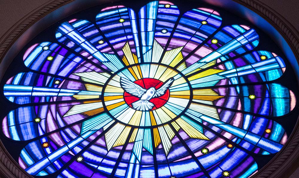 Holy Spirit represented in a stained glass window (Unsplash/Mateus Campos Felipe)