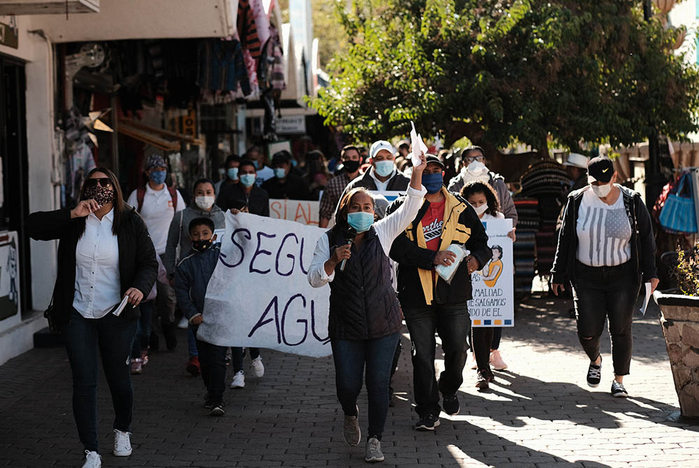 Migrant families participate Dec. 2 in the #SaveAsylum March through downtown Nogales, Sonora, Mexico. Their banner reads "Seguimos Agui" ("We're Still Here").  (Provided photo)